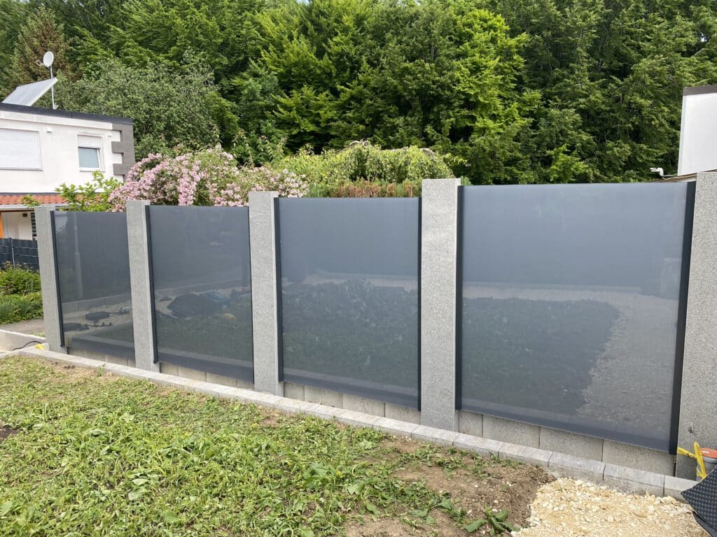 Sichtschutz aus Glas und Granit im Garten